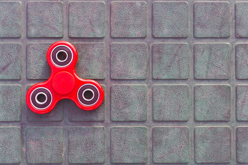 Top view of the popular red spinner gadget in 2017 on the blue-green background