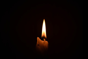Candle on the dark background isolated