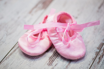 Children's pink shoes on a wooden background. Waiting for the girl.