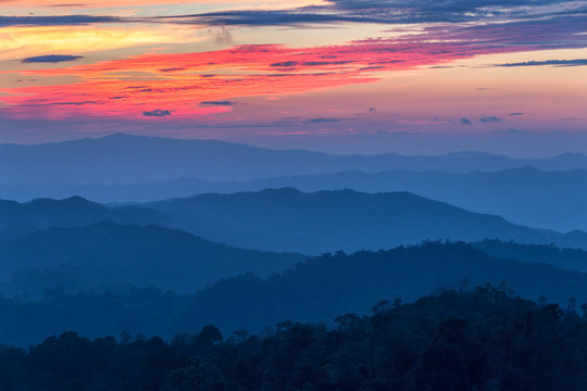 Layer of mountains in the mist at sunset time with burning sky, Nan Province, Thailand