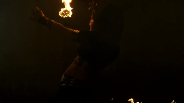 The girl shows a fiery show in an old hall 