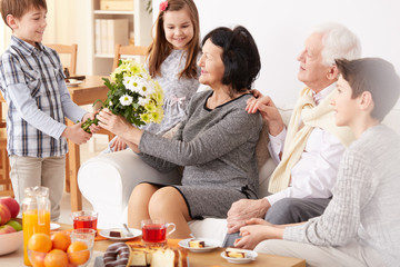 Boy giving flowers to grandmother