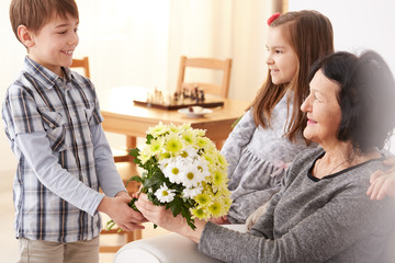 Grandson giving flowers to grandma