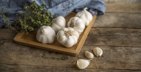 garlic and kitchen herbs on wooden table
