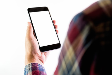 The man in a red plaid shirt stands holding a smartphone blank screen. Take your screen to put on advertising.
