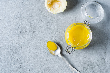 Lemon curd and ingredients on a gray concrete background