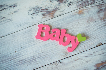 Wooden text pink baby on a wooden background.