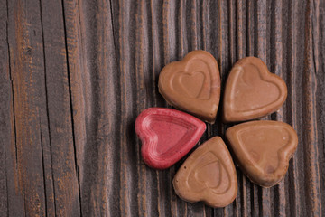 Chocolate heart-shaped candy on wooden background