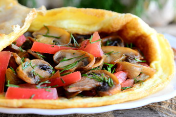 Vegetarian omelette recipe. Homemade omelette stuffed with chopped fresh tomatoes and fried mushrooms. Closeup