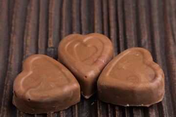Chocolate heart-shaped candy on wooden background