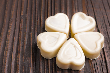 Chocolate heart-shaped candy on wooden background