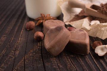 Chocolate heart-shaped candy on a rustic background, chocolate composition