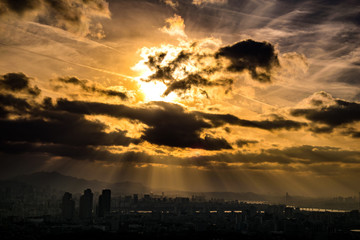 Fototapeta premium South Korea. Light sunset scenery through the black clouds of the sky of Seoul.