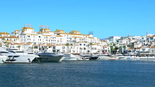 UHD 4k Puerto Banus near Marbella, Spain. Slow pan left to right of the harbour in Puerto Banus Spain showing the super yachts and motor cruisers of the rich and famous.