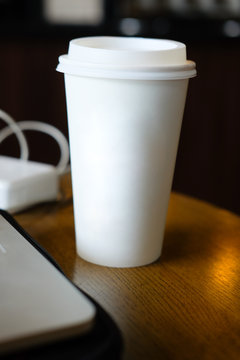 Take away white paper cups with laptop