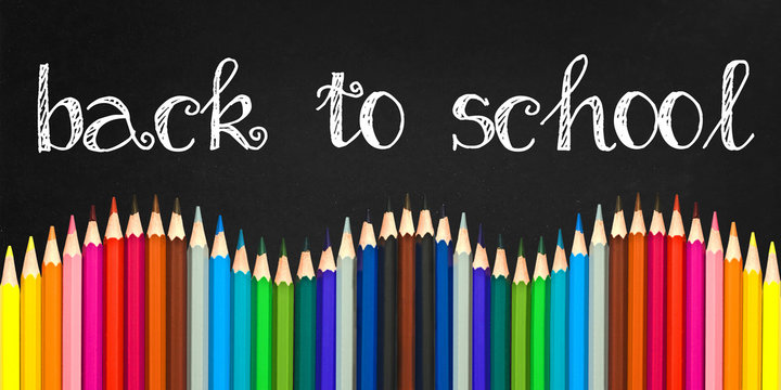 Back to school written on a black board background with a wave of colorful wooden pencils