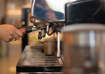 Hand holding a coffee machine in a coffee shop, business concept.