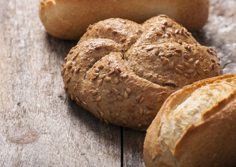 Variety of bread loaves on a white wooden table.