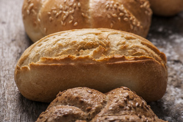 Variety of bread loaves on a white wooden table.