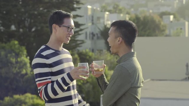 Gay Men Chat At A Rooftop Party, Their Friend Joins Them And Wants To Take A Photo Together, They Pose And Then Laugh At Photo 