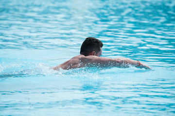 Man swimmer athlete brunette swimming in pool