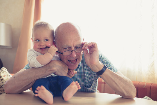 Grandfather playing with baby at table