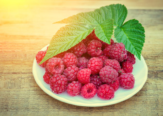 raspberry in a plate on wooden table