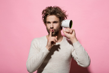 hush gesture of man overhear with cup