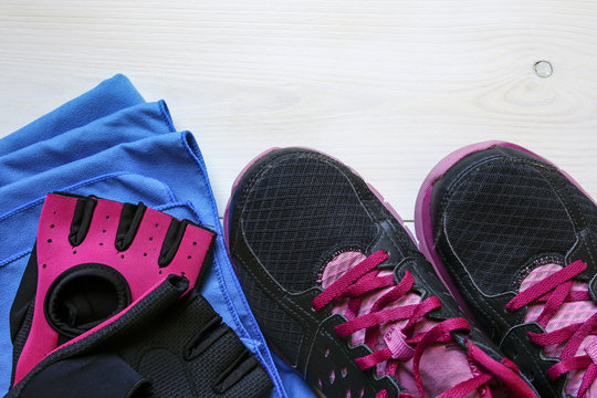 fitness concept equipment- sneakers, workout gloves and towel