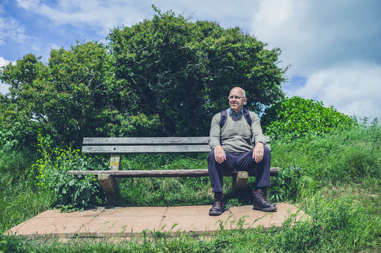 Senior man relaxing on bench in nature