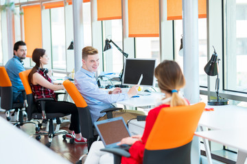 startup business, young creative people group brainstorming on meeting at office interior and using laptop and tablet computer to note ideas plans and projects