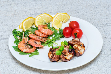 Shrimps with mushrooms and vegetables on white plate. Home cooked exotic food.