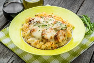 Pasta bake with broccoli and chicken. On a wooden table