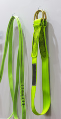 Colorful Cross arm straps hang on a white wall ; safety equipment