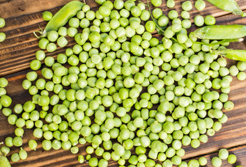 green pea in a vase on a brown wooden background