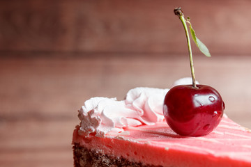 Chocolate cake with cherries on wooden background