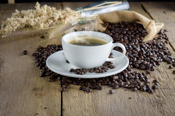 Coffee cup with coffee beans on wood table