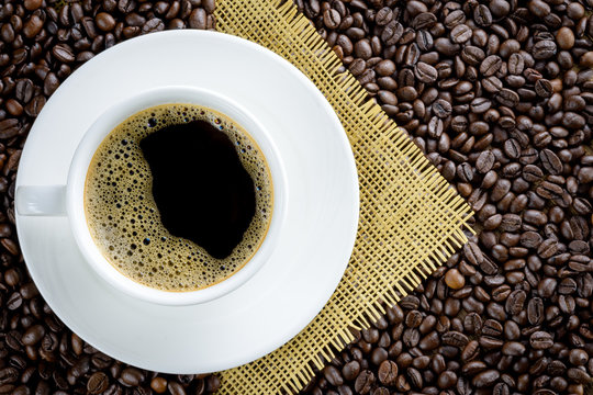 Coffee cup on coffee beans background © Yanawut Suntornkij