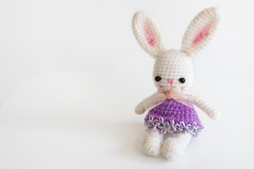 Handmade crochet doll. Cute rabbit doll on white background. With copy space.