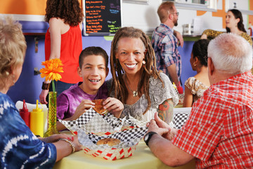 Mother and her teen son having lunch with seniors