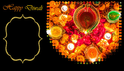 Diwali festival background concept with lighted clay diya oil lamps and lovely floral decorations with rose petals and marigold. Copy space for message content.