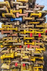 Colorful wooden parts of scaffolding from the folded stack in the warehouse. Abstract background.
