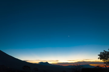 Sunrise clouds and mountains in Guatemala, dramatic sky with striking colors and moon. La Reunion.