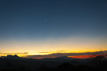 Sunrise clouds and mountains in Guatemala, dramatic sky with striking colors and moon. La Reunion.
