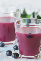 Blueberry juice.  Freshly prepared natural blueberry juice in glasses and ripe blueberries on an old wooden table. The concept of healthy eating.
