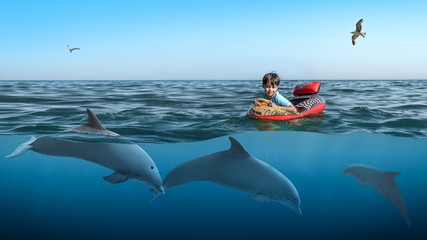 Ein Kind beobachtet Delfine von einem Gummiboot © Konstantin Hermann