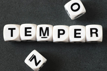 word temper on toy cubes