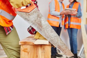 Handwerker sägt Holz mit Handsäge