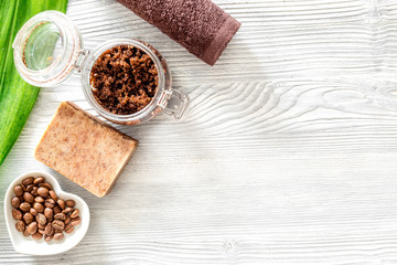 Homemade skin care. Coffee soap, coffee scrub, coffee grains on wooden background top view copyspace