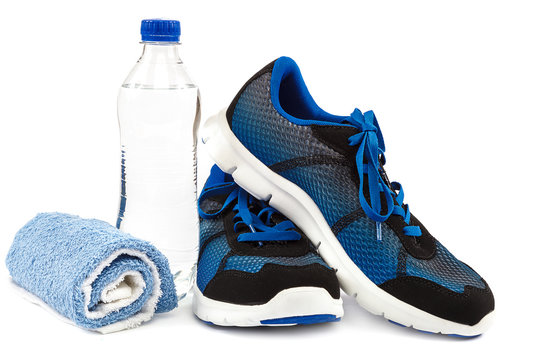 Stylish sneakers, towel and water bottle on white background.